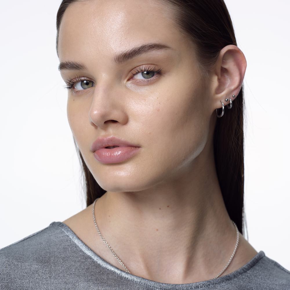 kobieta z długimi włosami i srebrnym naszyjnikiem