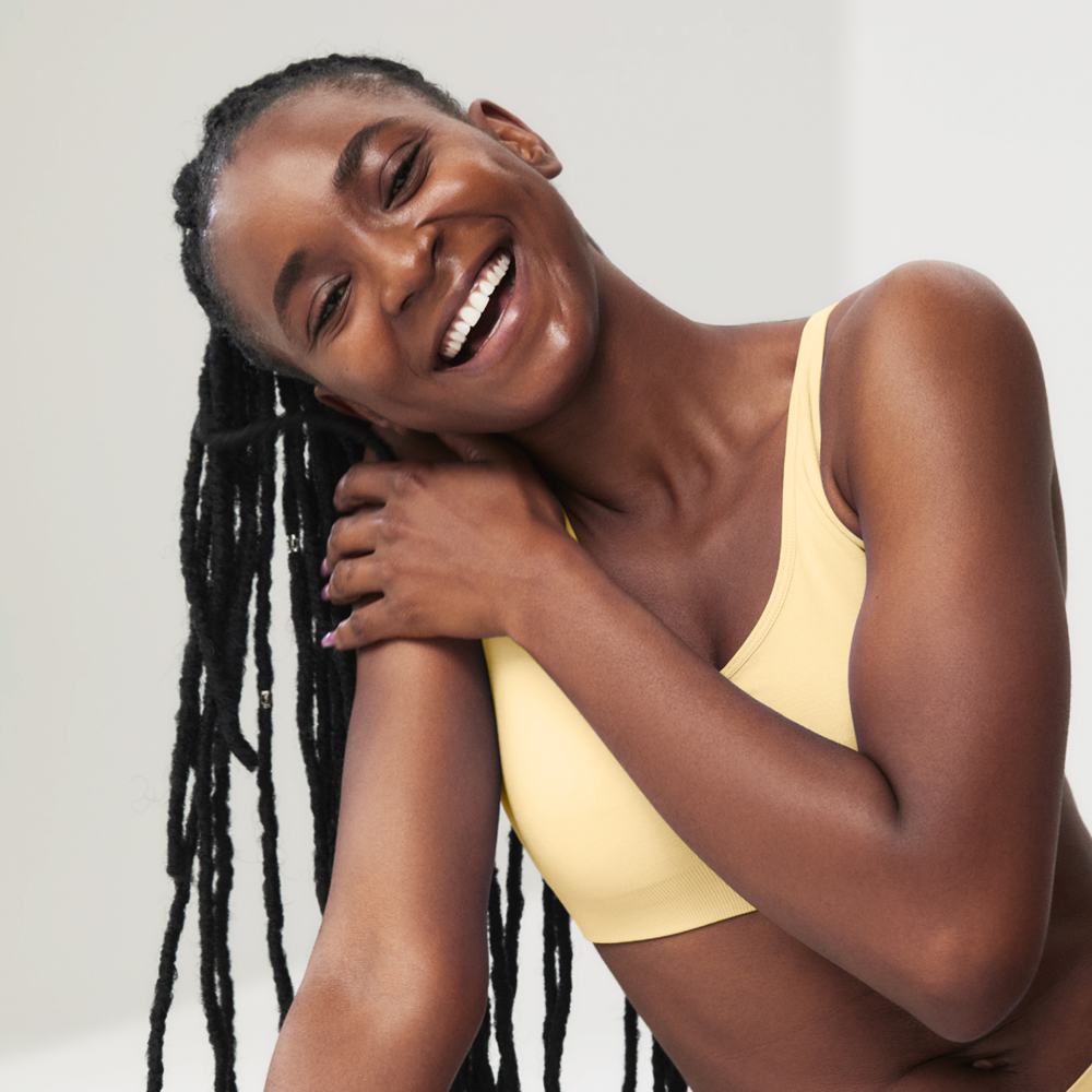 μια γυναίκα που χαμογελά με το χέρι της στον ώμο της