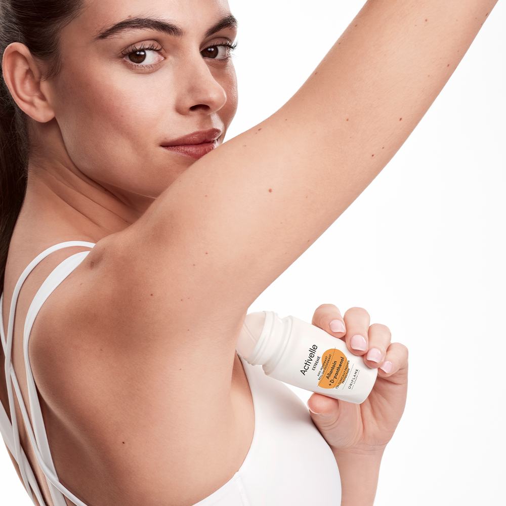 женщина, держащая флакон дезодоранта