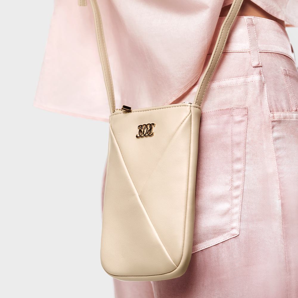 roosade pükste ja valge käekotiga naine