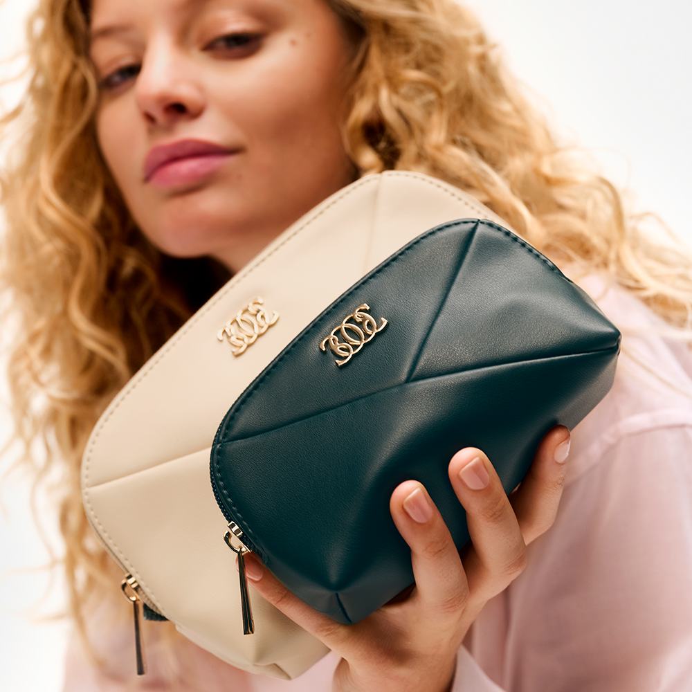 a woman holding two small purses