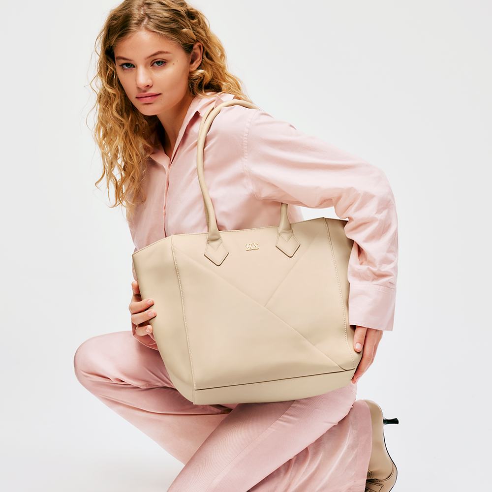 roosas pidžaamas naine, kes hoiab käekotti