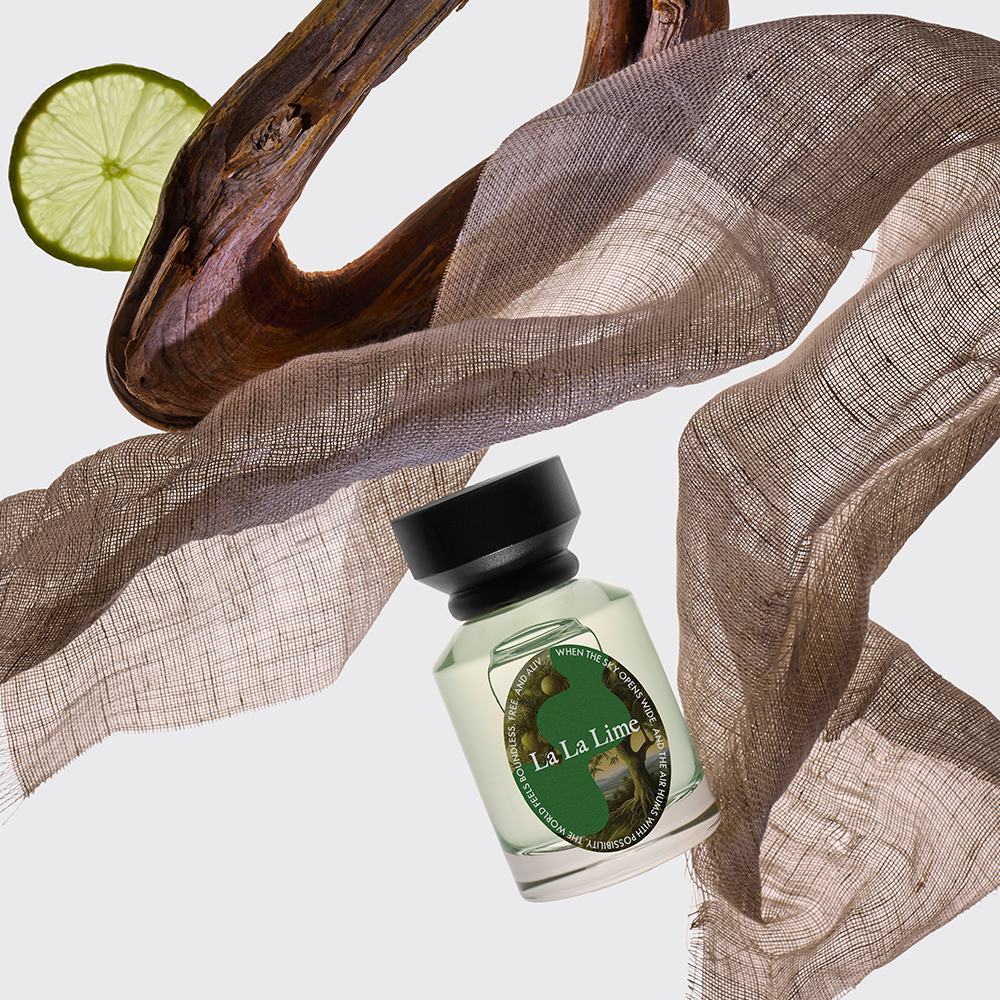 butelka perfum z kawałkiem materiału i kawałkiem drewna