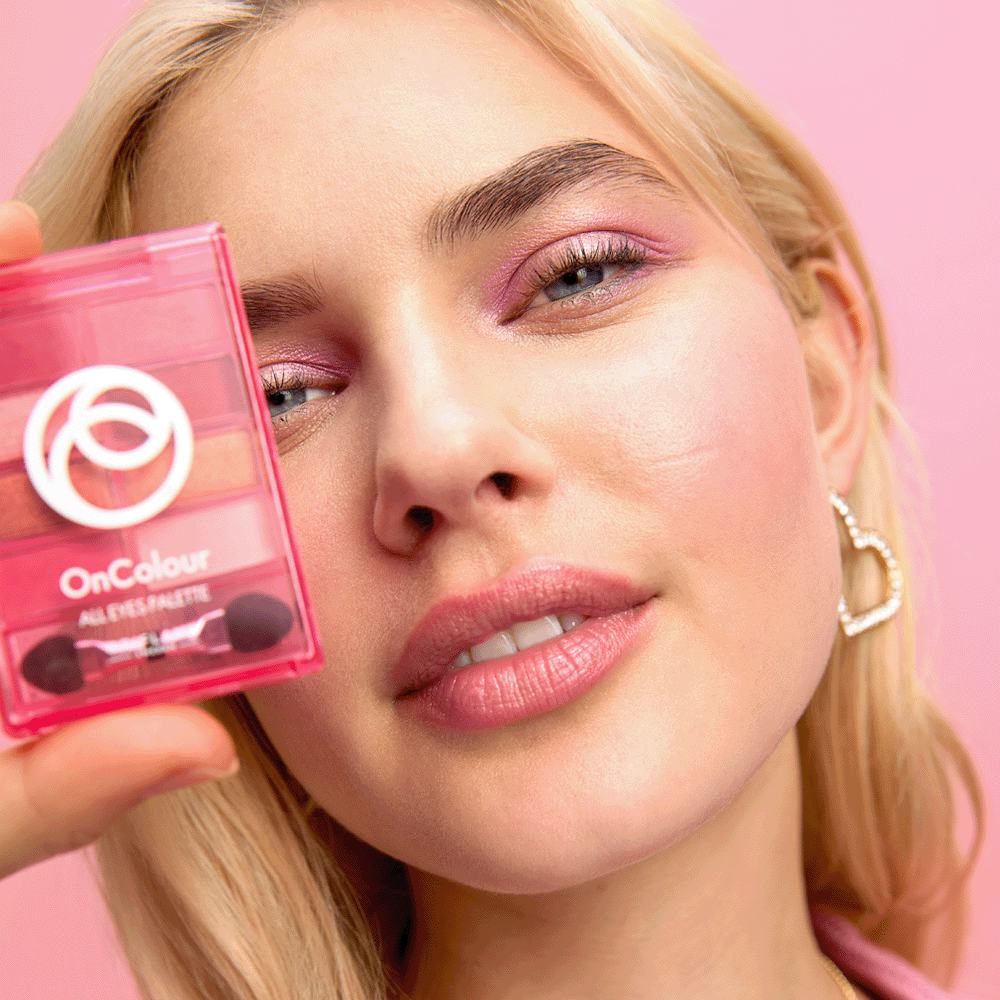 Kobieta trzymająca różowe pudełko z kosmetykami do makijażu