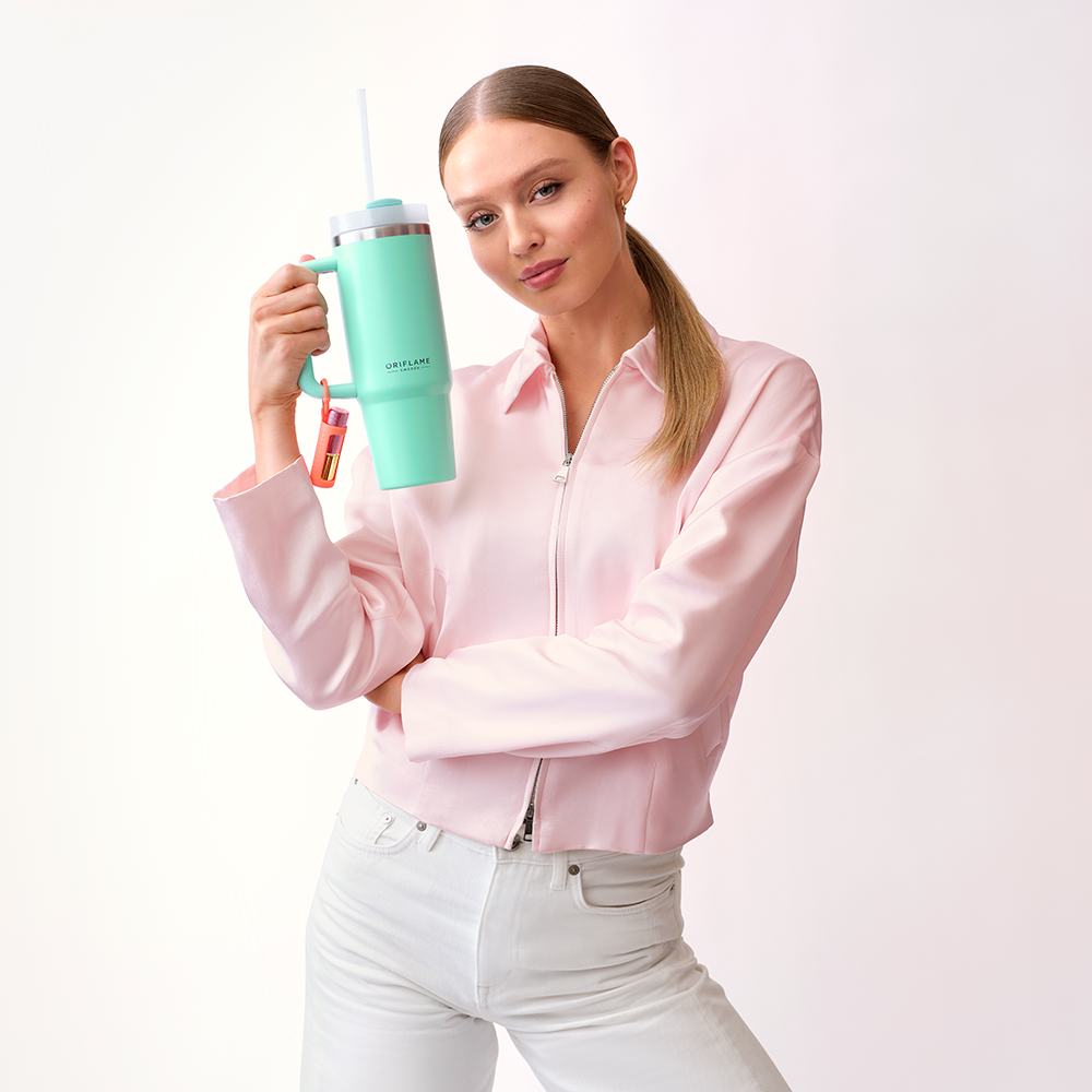 egy nő, aki egy zöld csészét tart a kezében