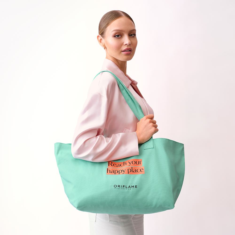 μια γυναίκα που κρατά μια πράσινη τσάντα