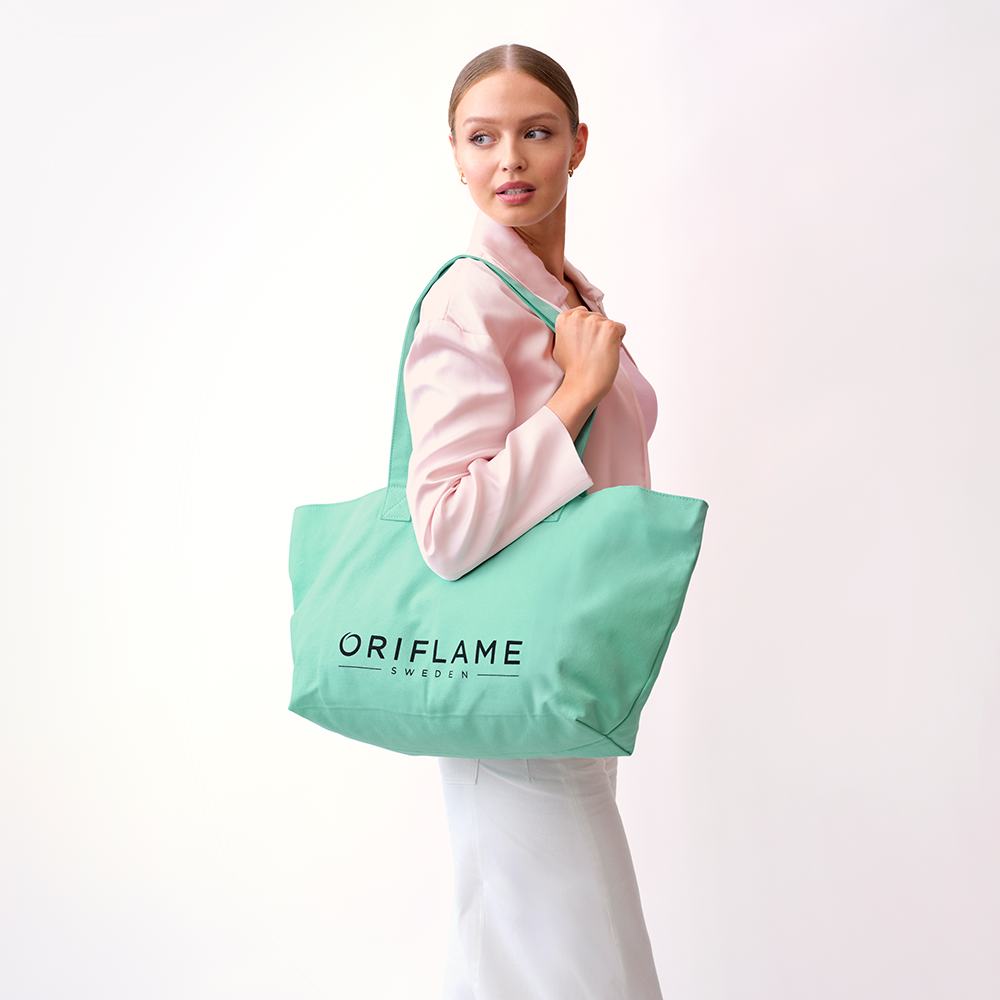 μια γυναίκα που κρατά μια πράσινη τσάντα