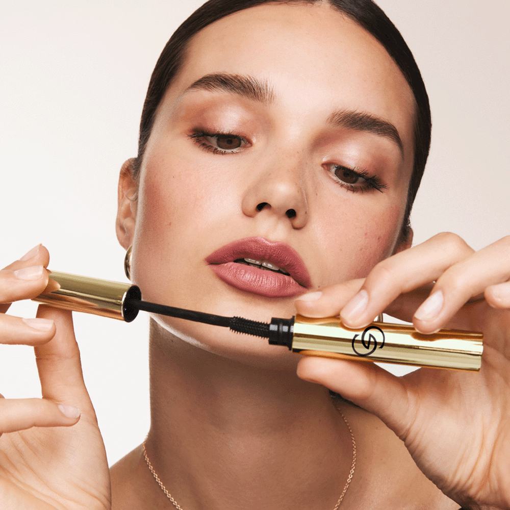 женщина, держащая тюбик туши