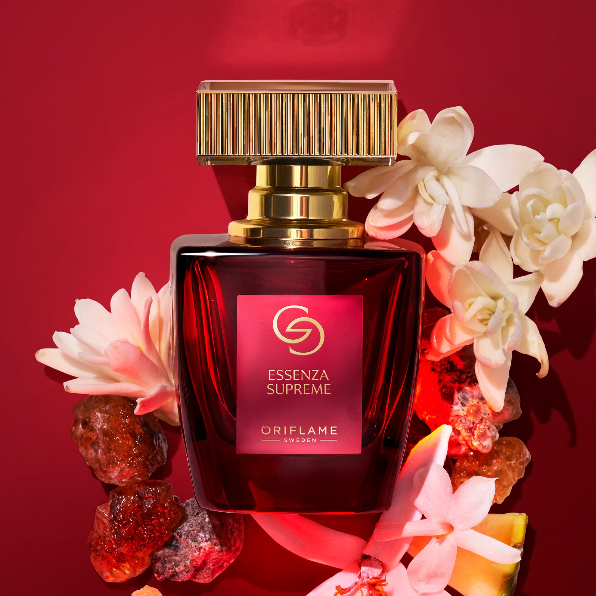 Sebotol parfum dikelilingi oleh bunga