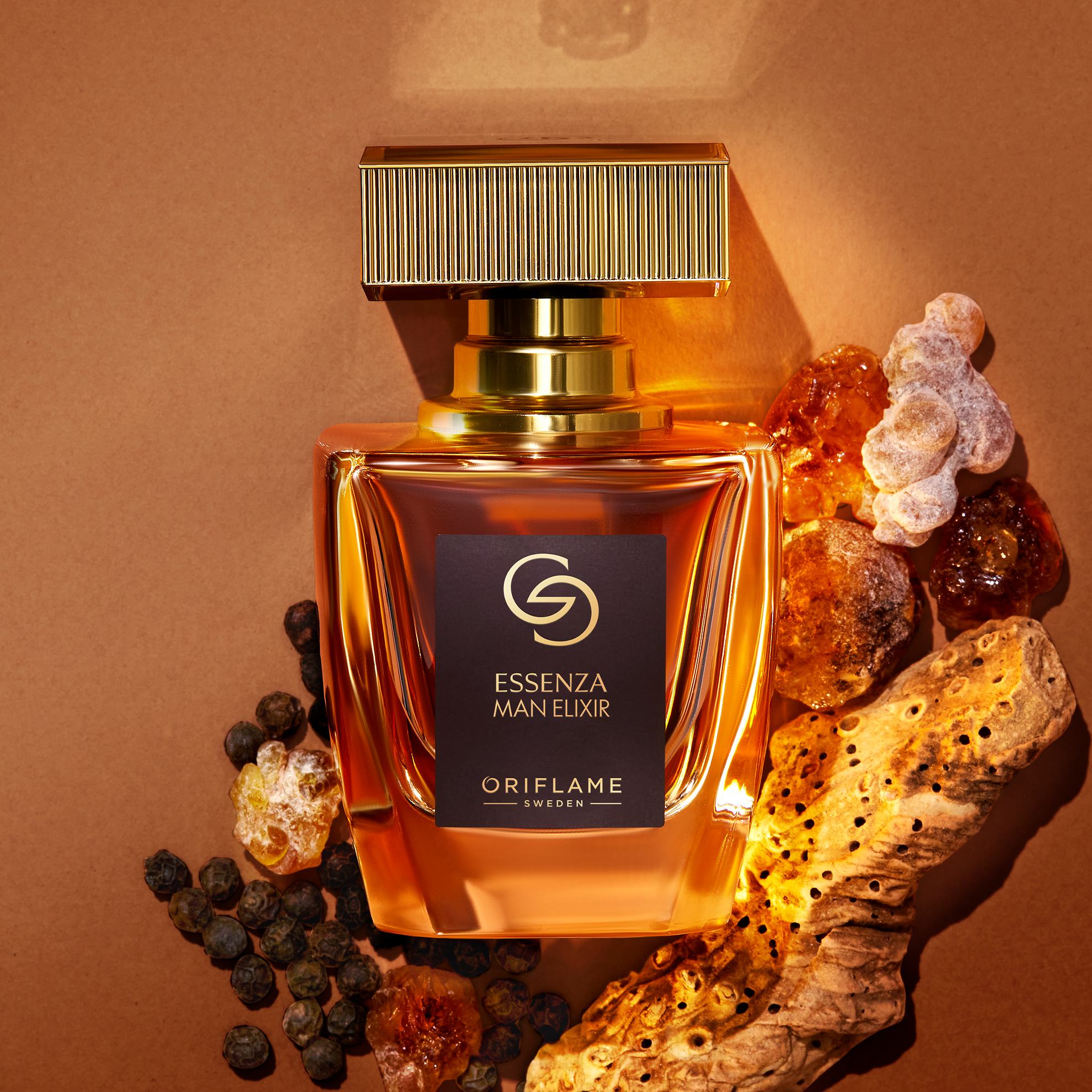 Sebotol parfum di samping beberapa batu