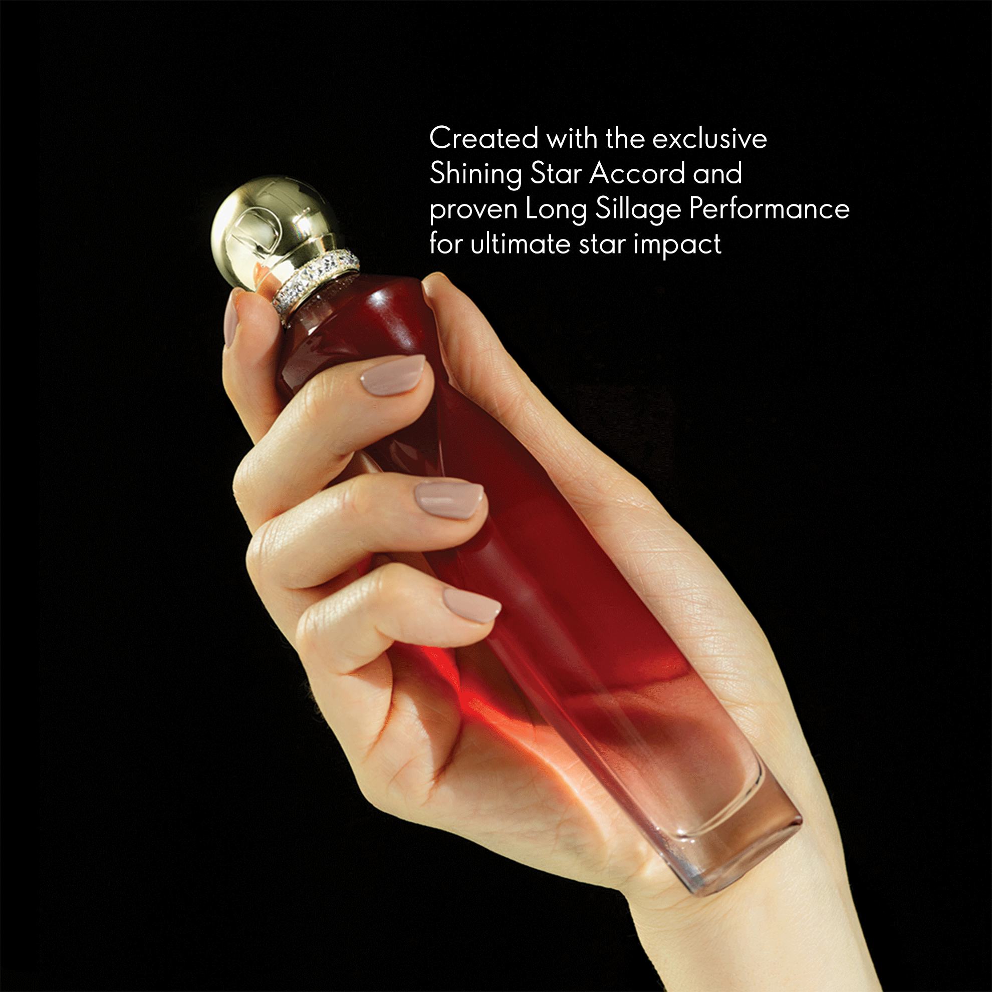 a hand holding a bottle of red liquid