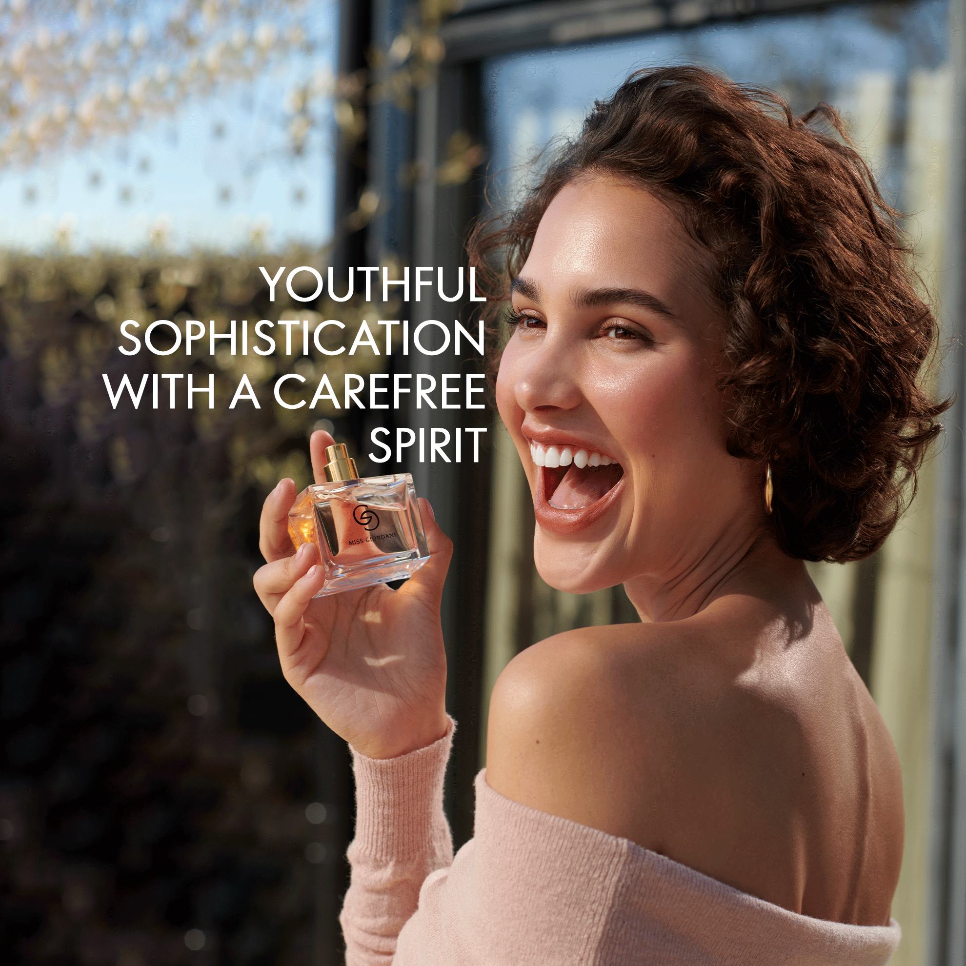 a woman holding a bottle of perfume