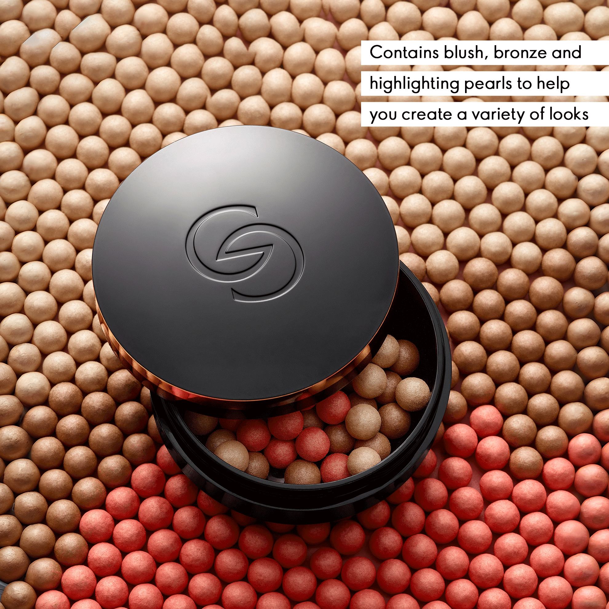 a black container with a black lid on top of a pile of round balls