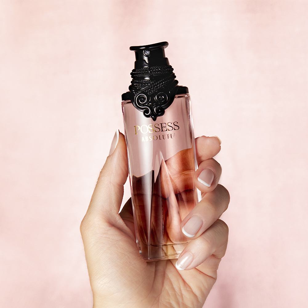 egy parfümös üveget tartó kéz