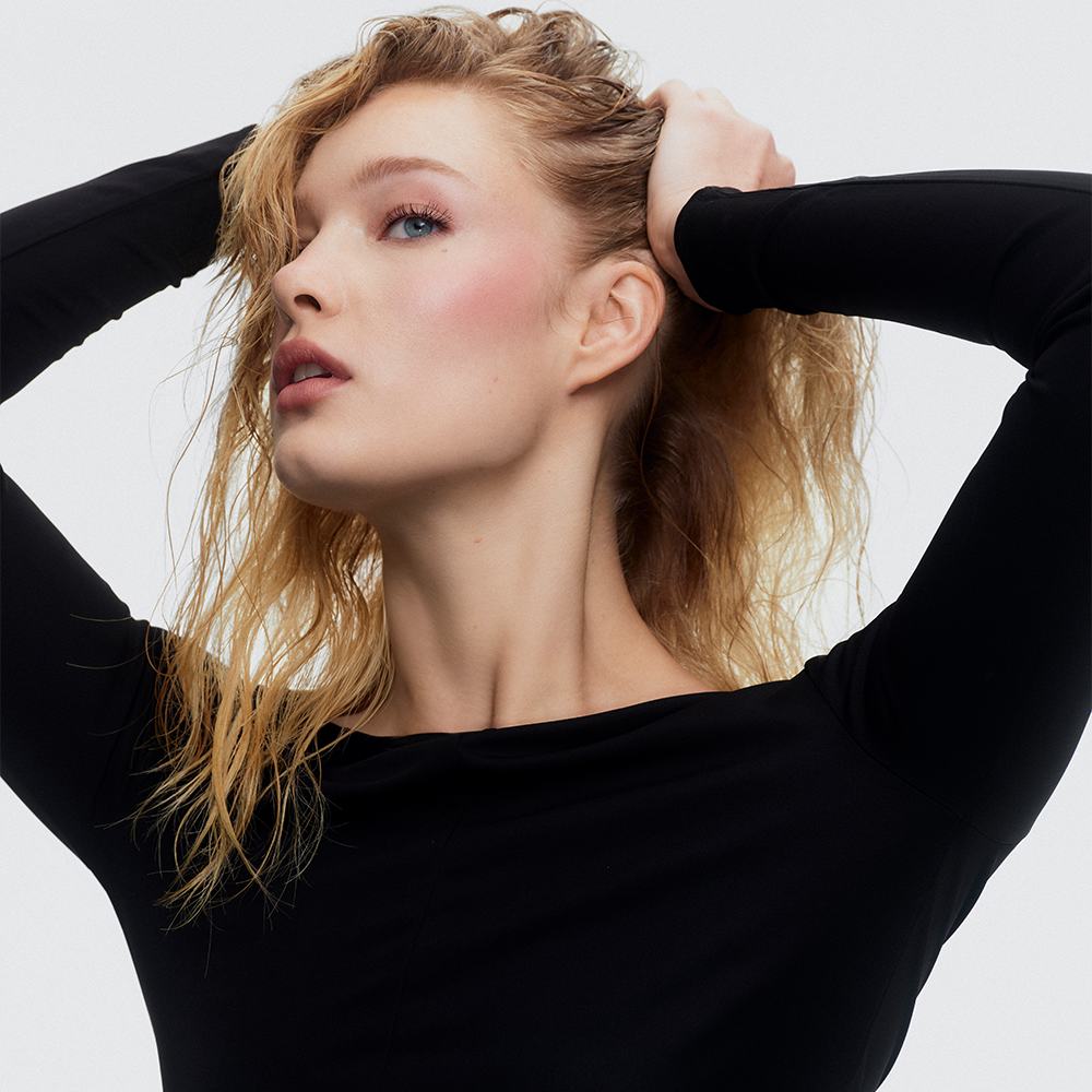 kobieta o blond włosach trzymająca swoje włosy