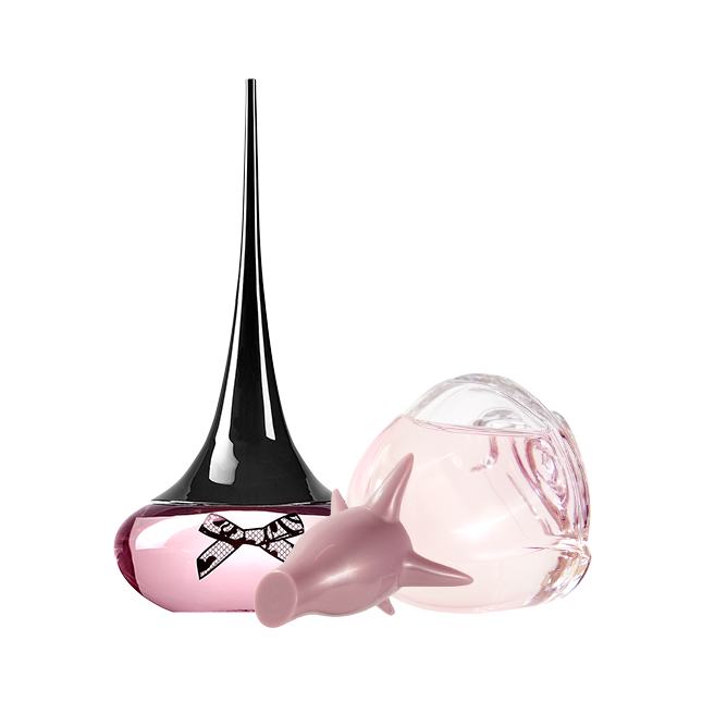 un frasco de perfume junto a un pequeño objeto rosa