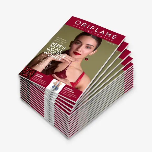 a stack of magazines with a woman holding a bottle