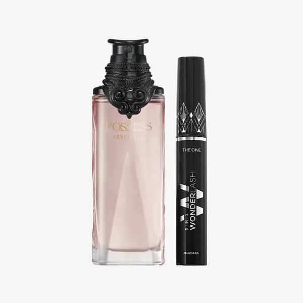 un frasco de perfume junto a una máscara de pestañas