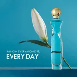 a bottle of perfume next to a flower