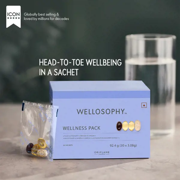 a blue box with yellow and orange pills in it next to a glass of water