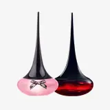 un par de frascos de perfume con la Torre Eiffel de fondo