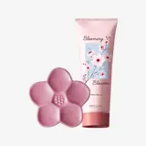 un tubo rosa de crema junto a una flor rosa