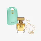 un frasco de perfume junto a un bolso