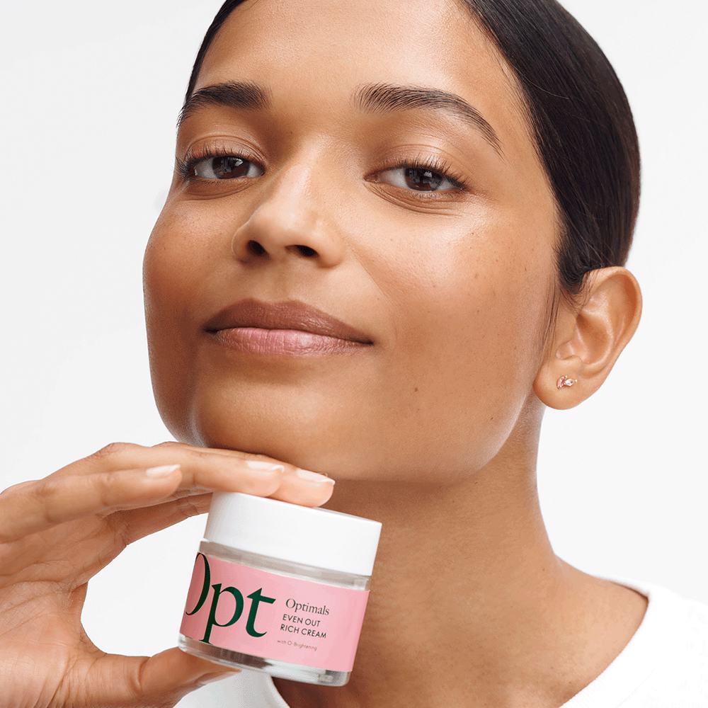 a woman holding a jar of cream