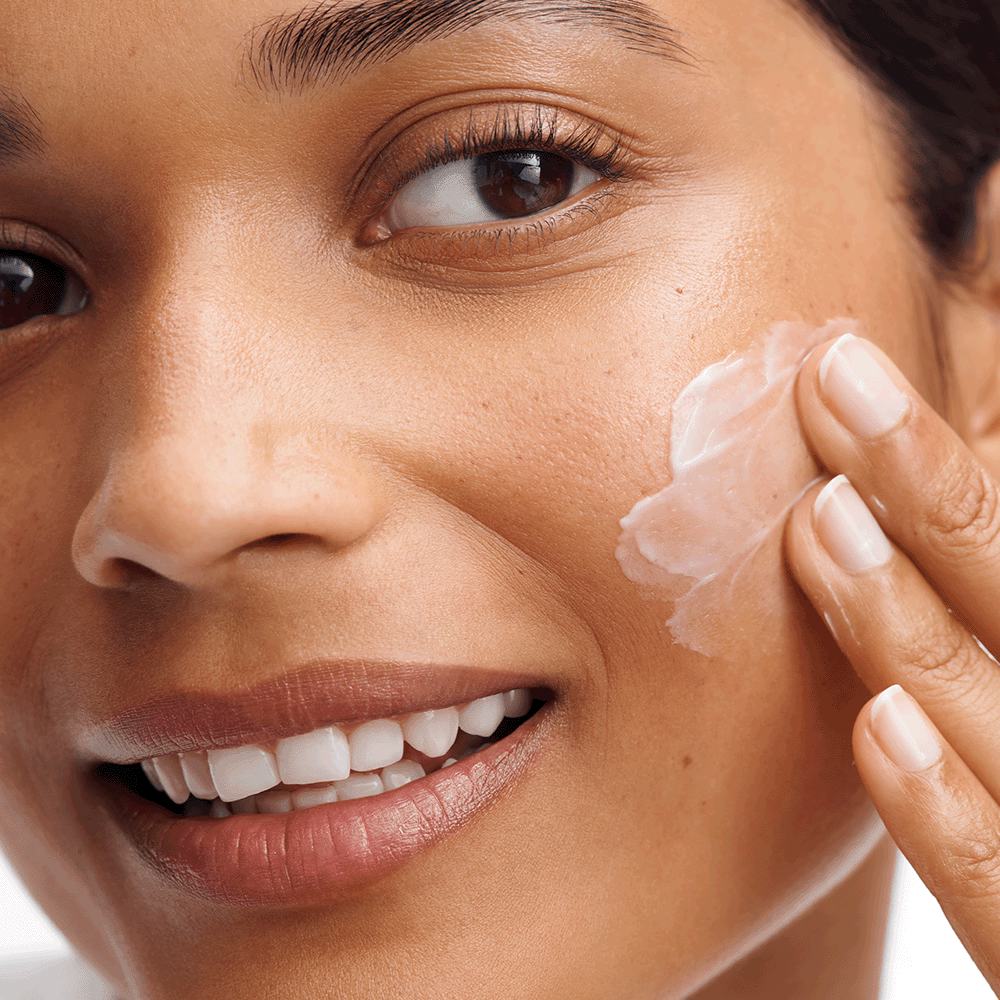 a woman applying cream on her face