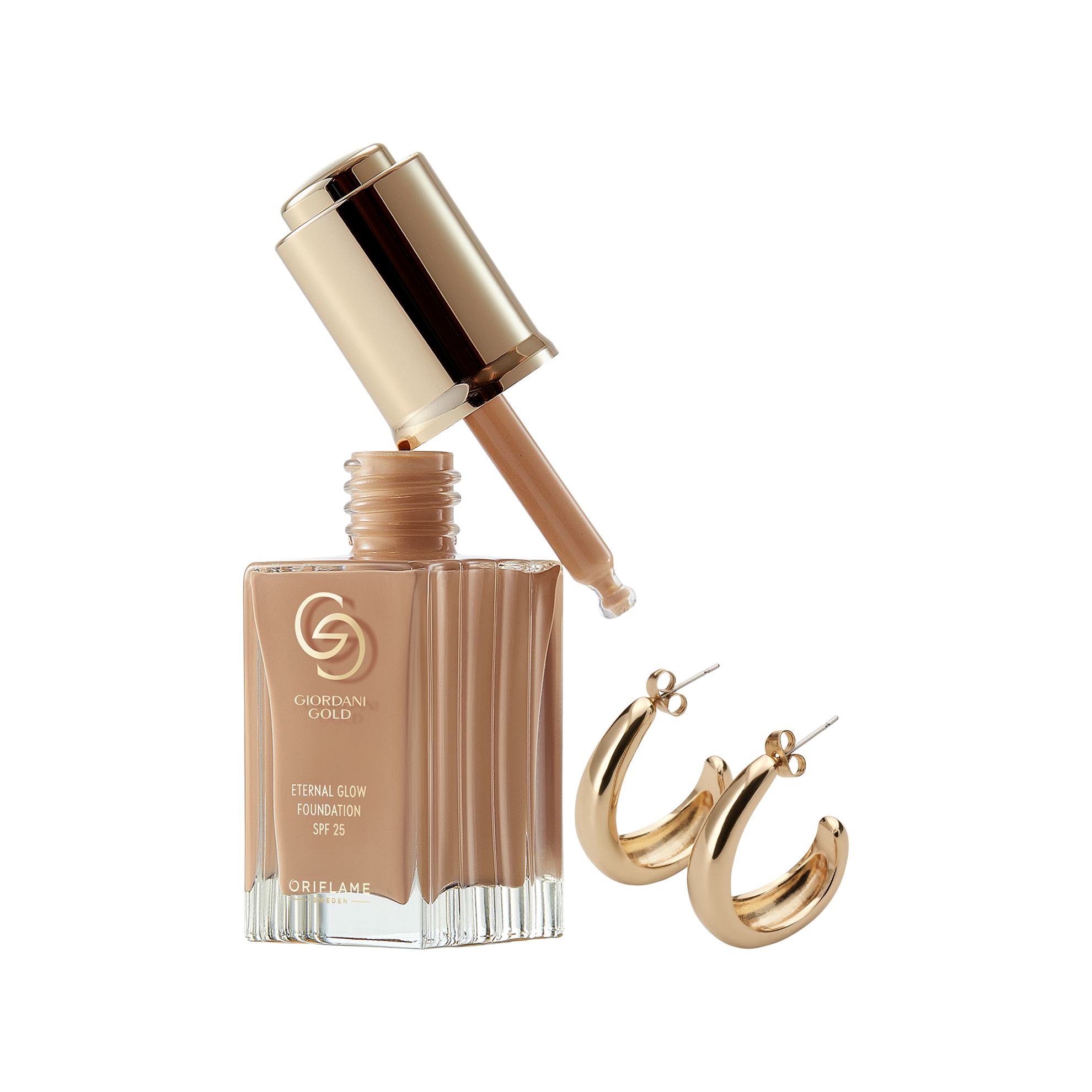 a bottle of liquid foundation with gold hoop earrings