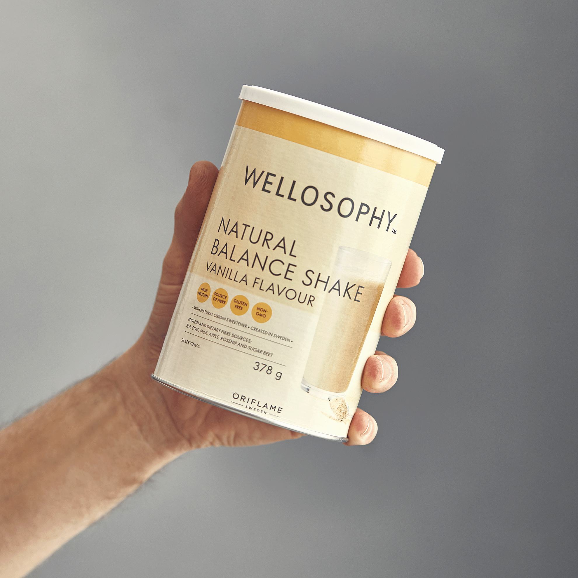 a hand holding a container of shake