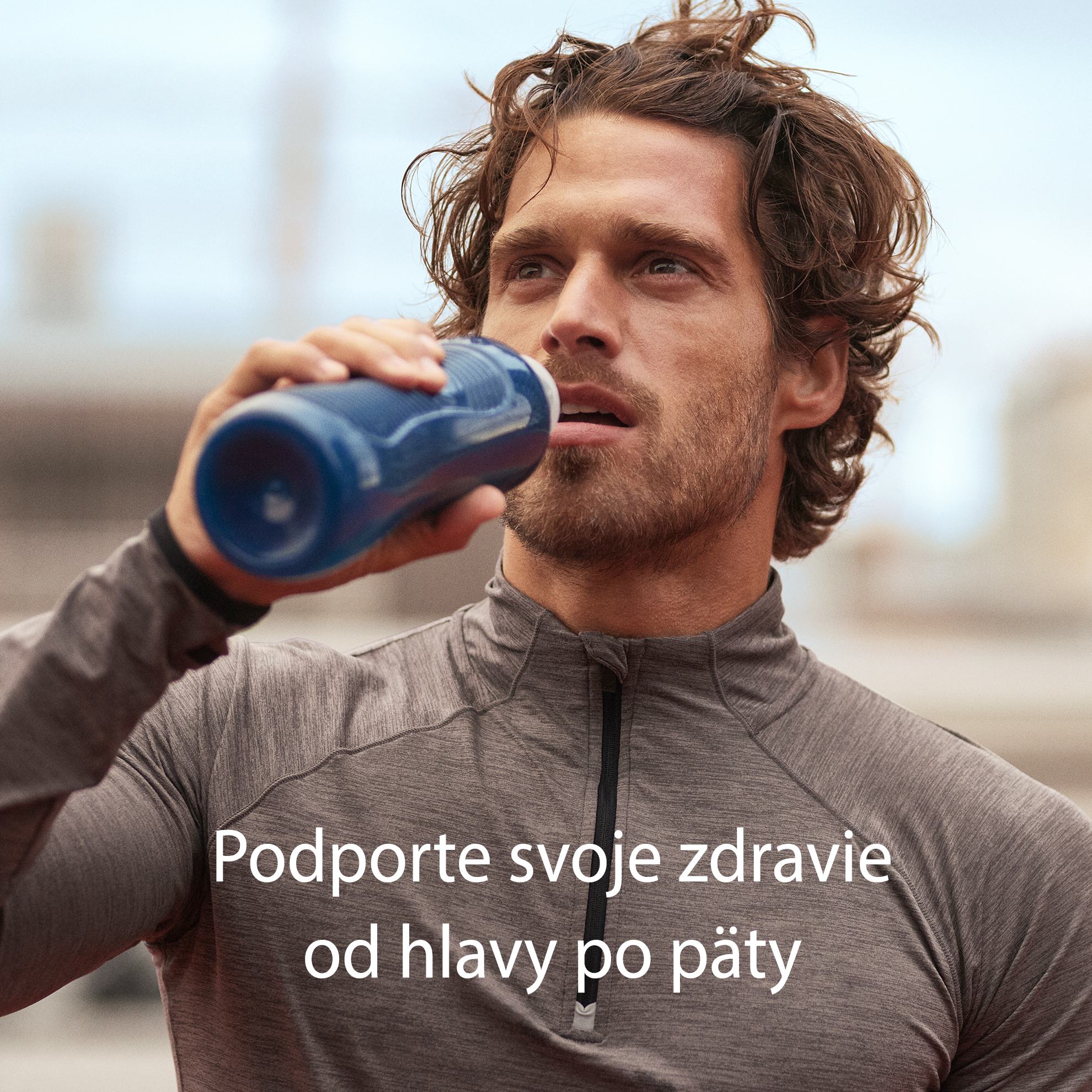 muž pije z modrej fľaše