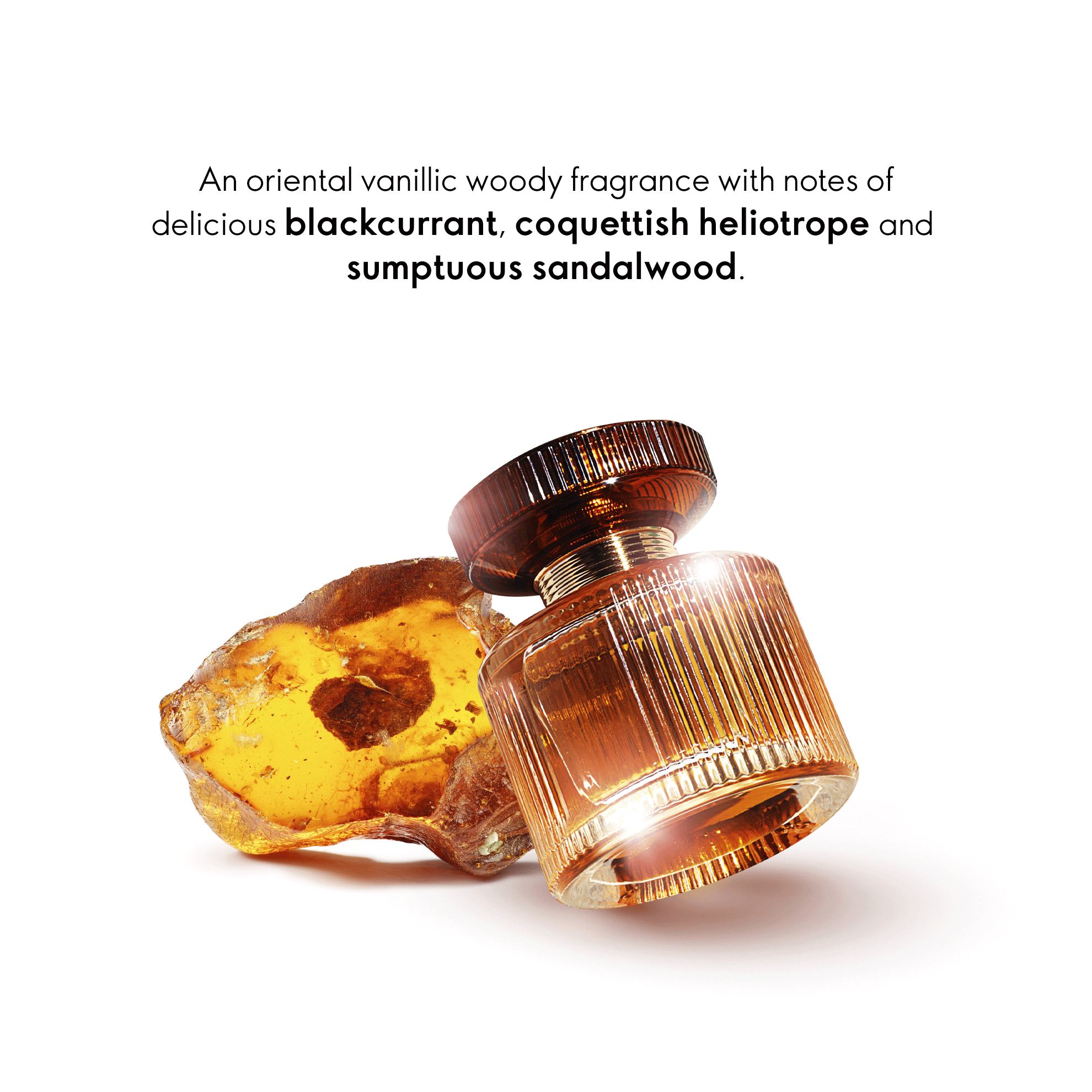 a bottle of perfume next to a piece of amber