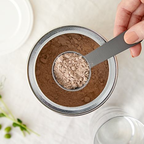 persona, kas tur karoti virs pulvera trauka