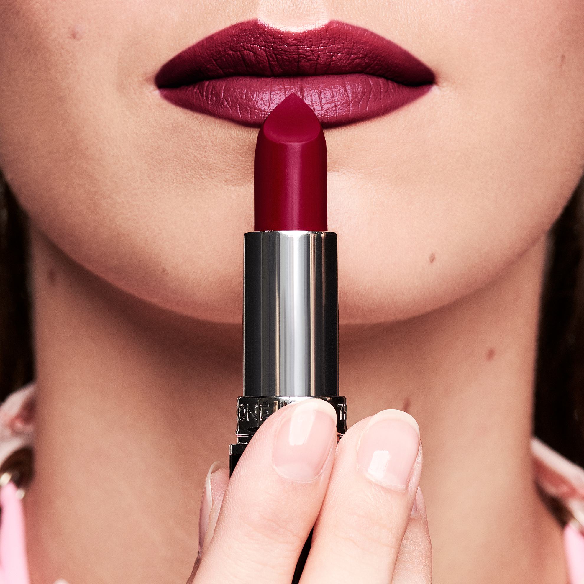 a woman holding a lipstick