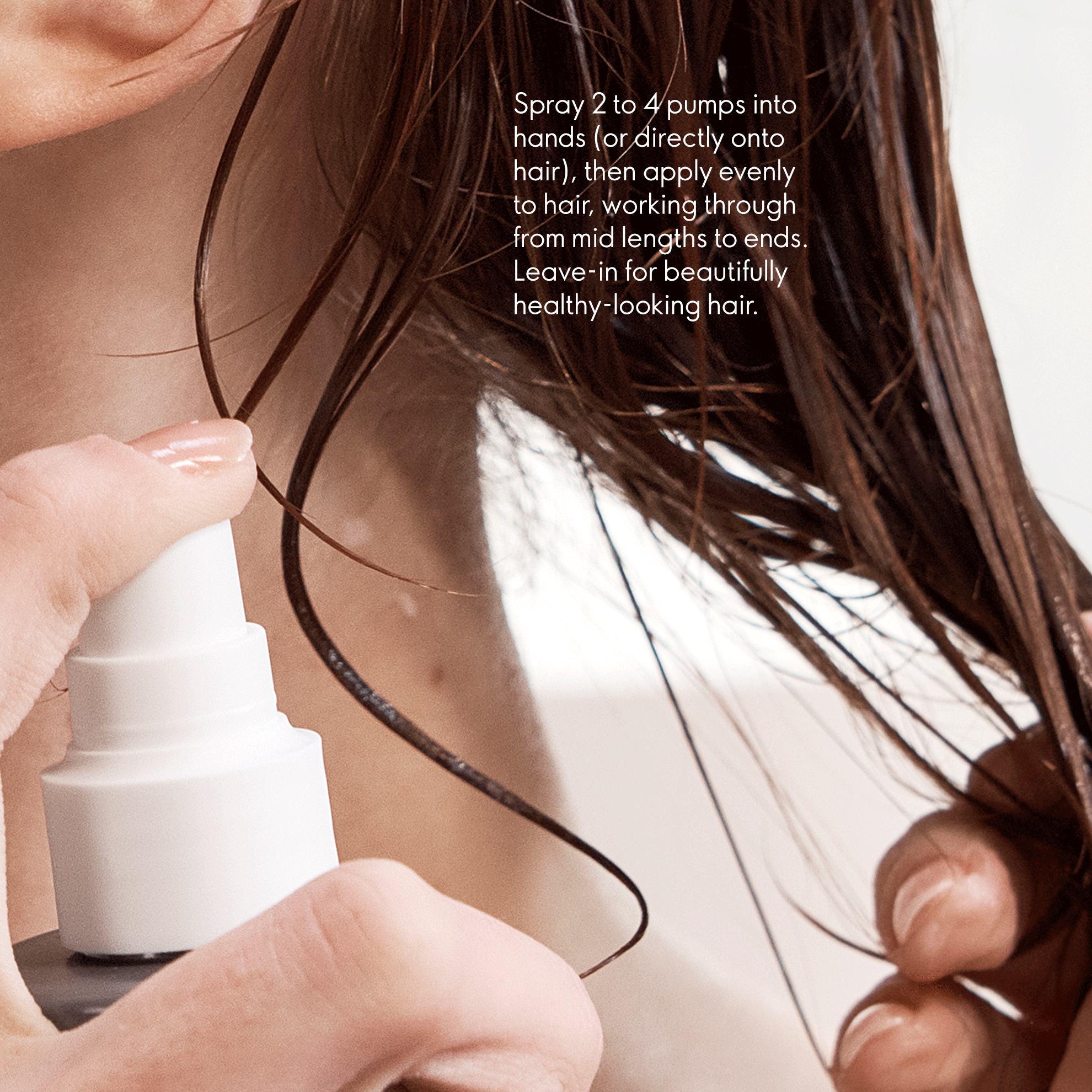 a person spraying hair with a spray bottle