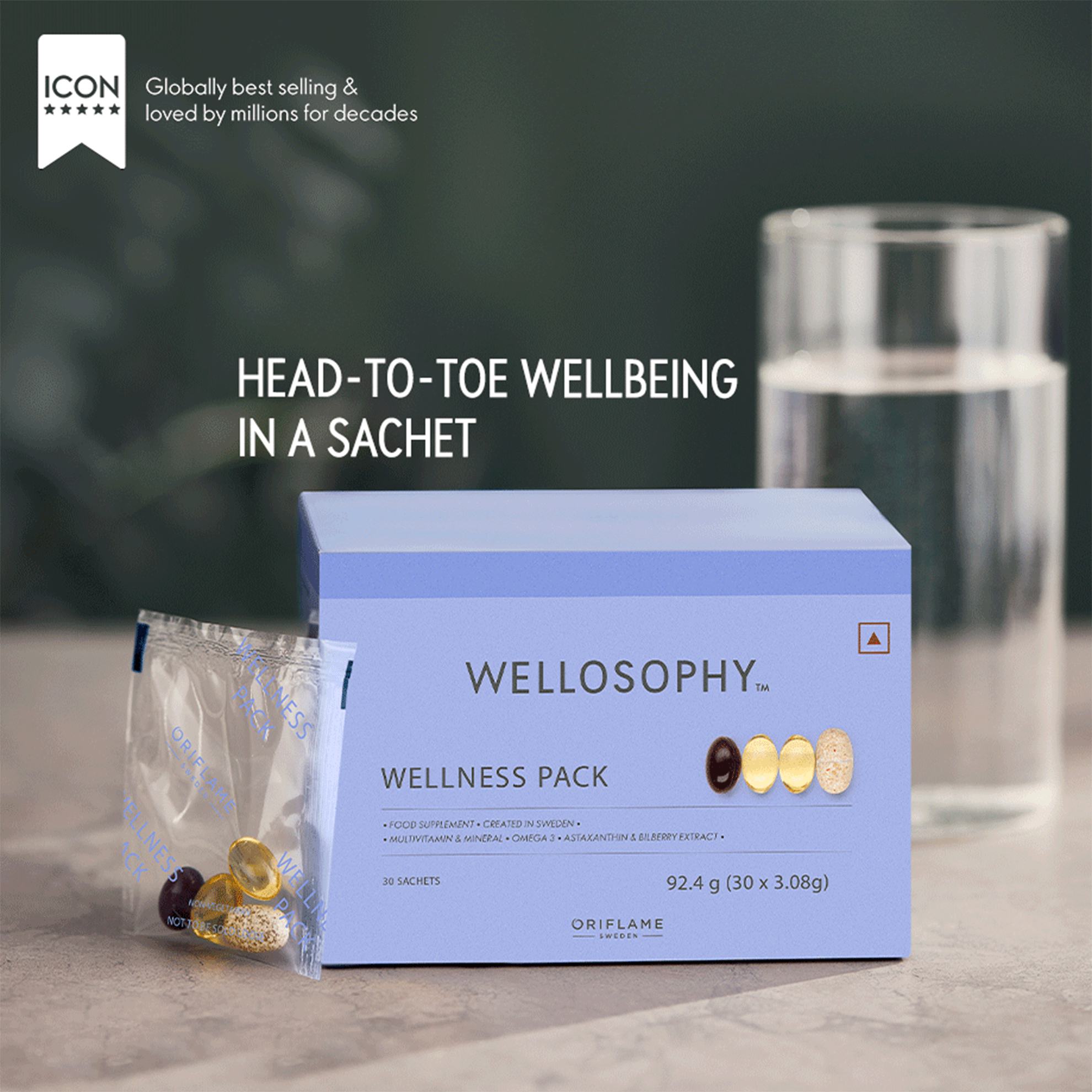 a blue box with yellow and orange pills in it next to a glass of water