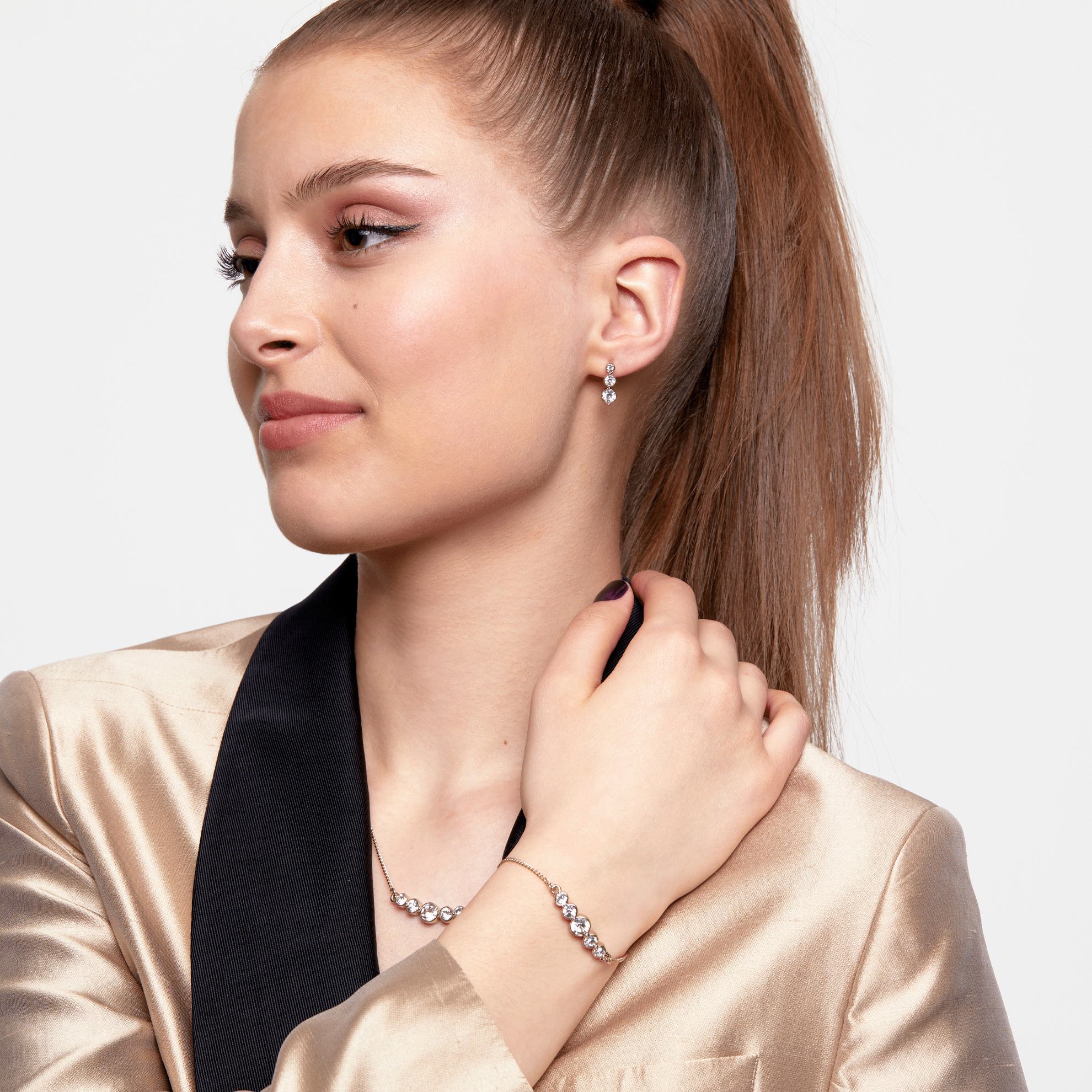 a woman with a ponytail and a gold jacket