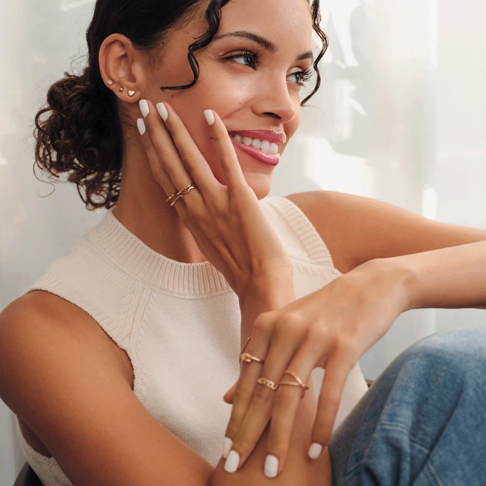 en kvinna som ler med händerna på ansiktet