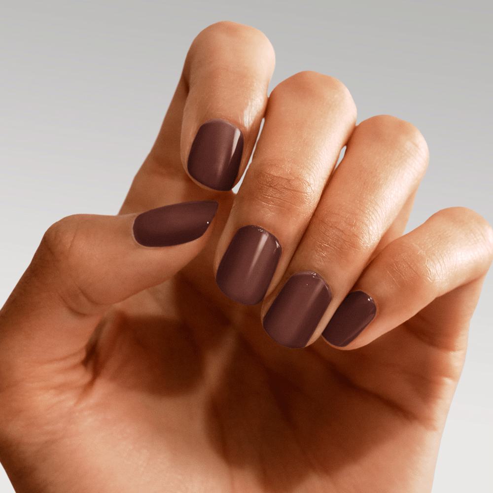 een hand met bruin gelakte nagels