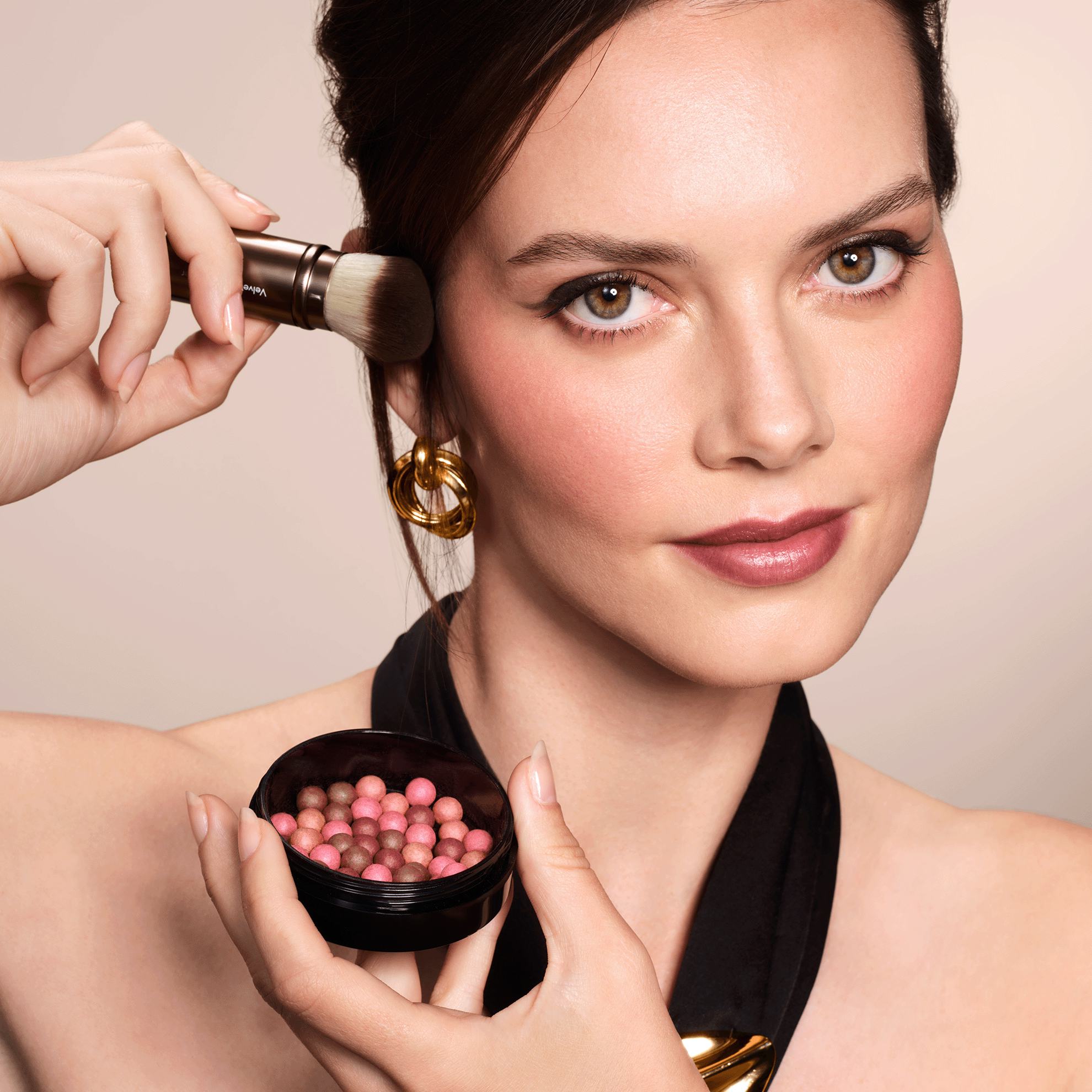 женщина наносит румяна на лицо