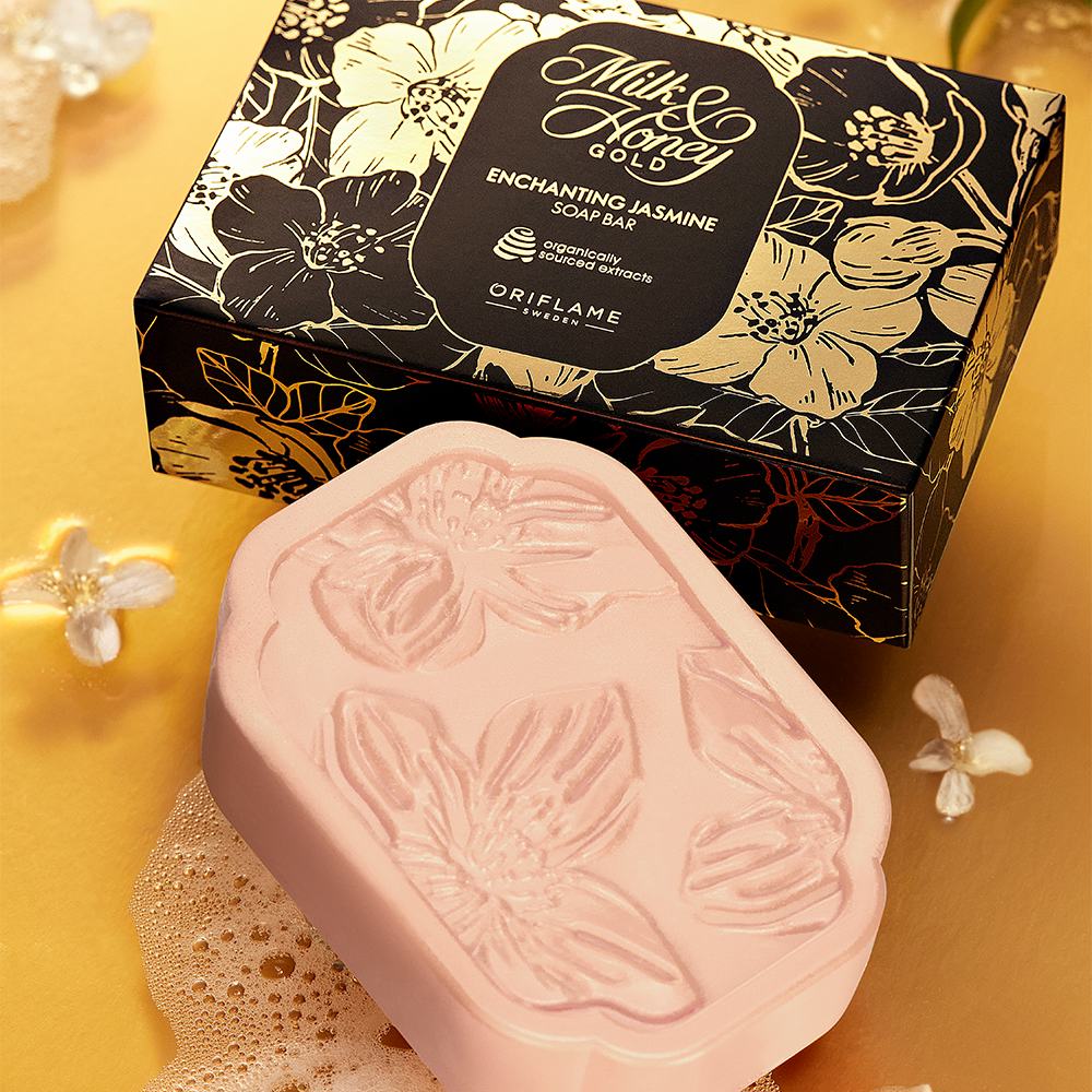 üzerinde çiçekler bulunan pembe bir sabun, bir kutunun yanında