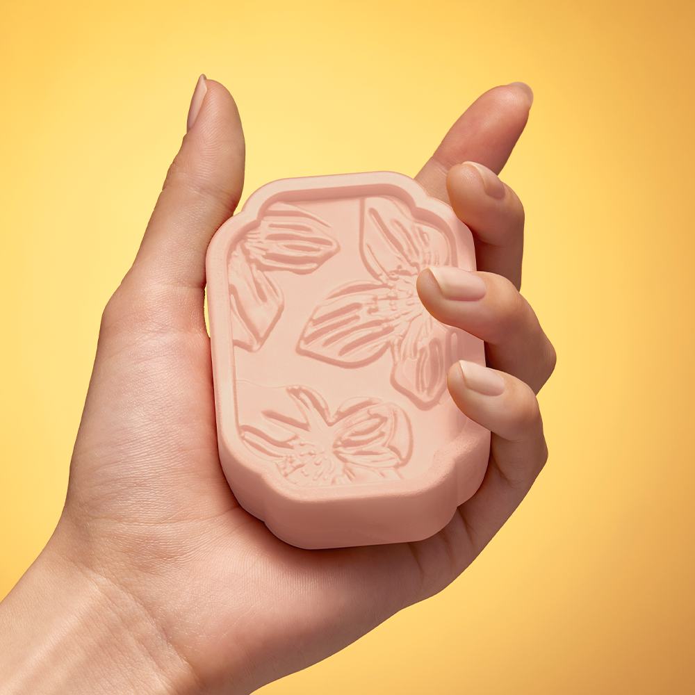 pembe sabun tutan bir el