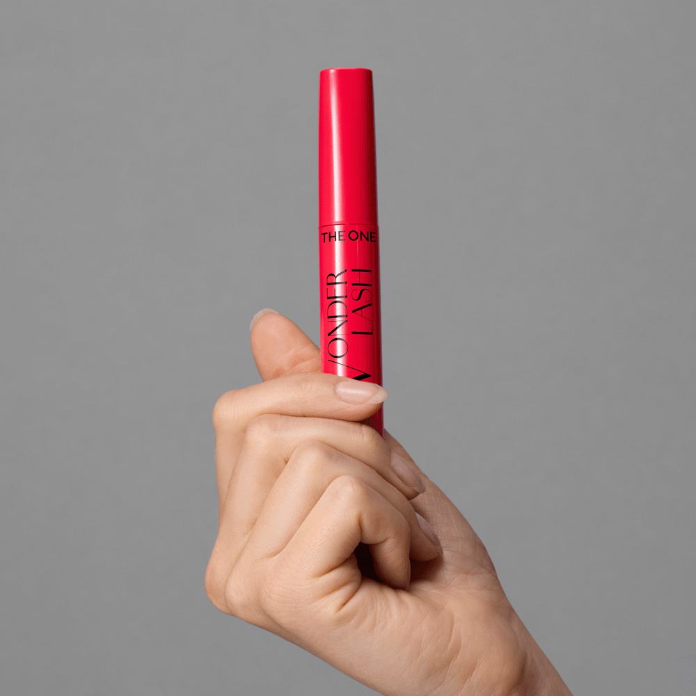 o mână care ține un tub roșu de rimel