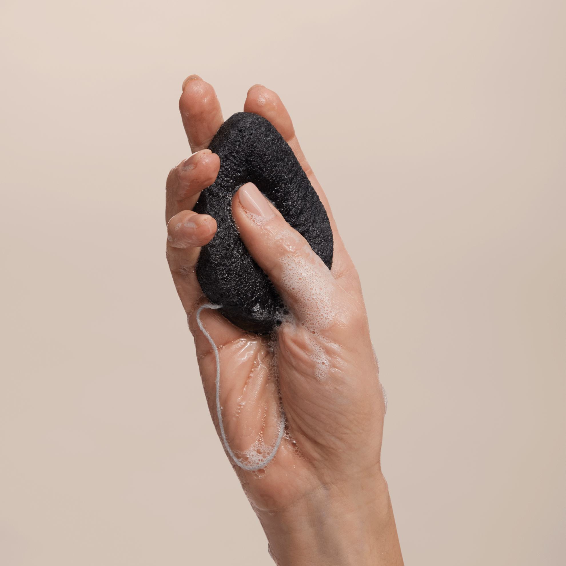 a hand holding a black sponge