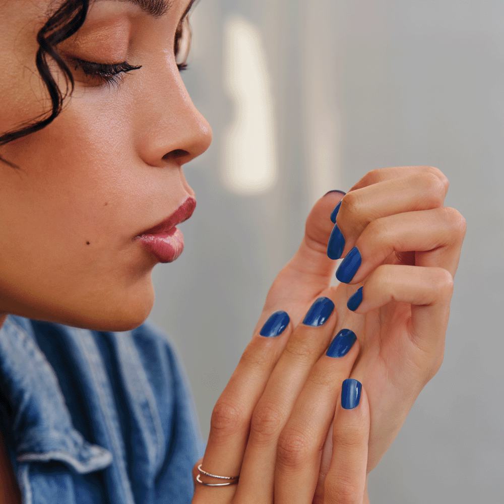 μια γυναίκα με μπλε βαμμένα νύχια