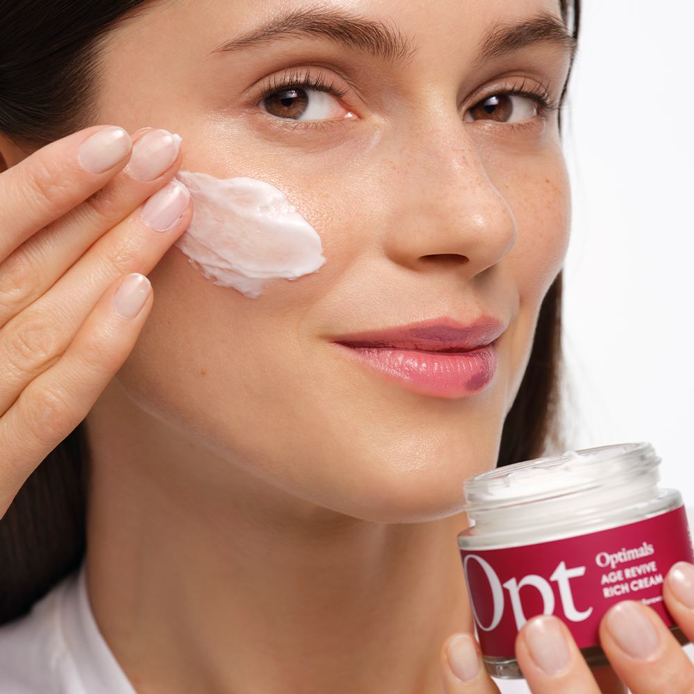 ženska, ki si nanaša kremo na obraz