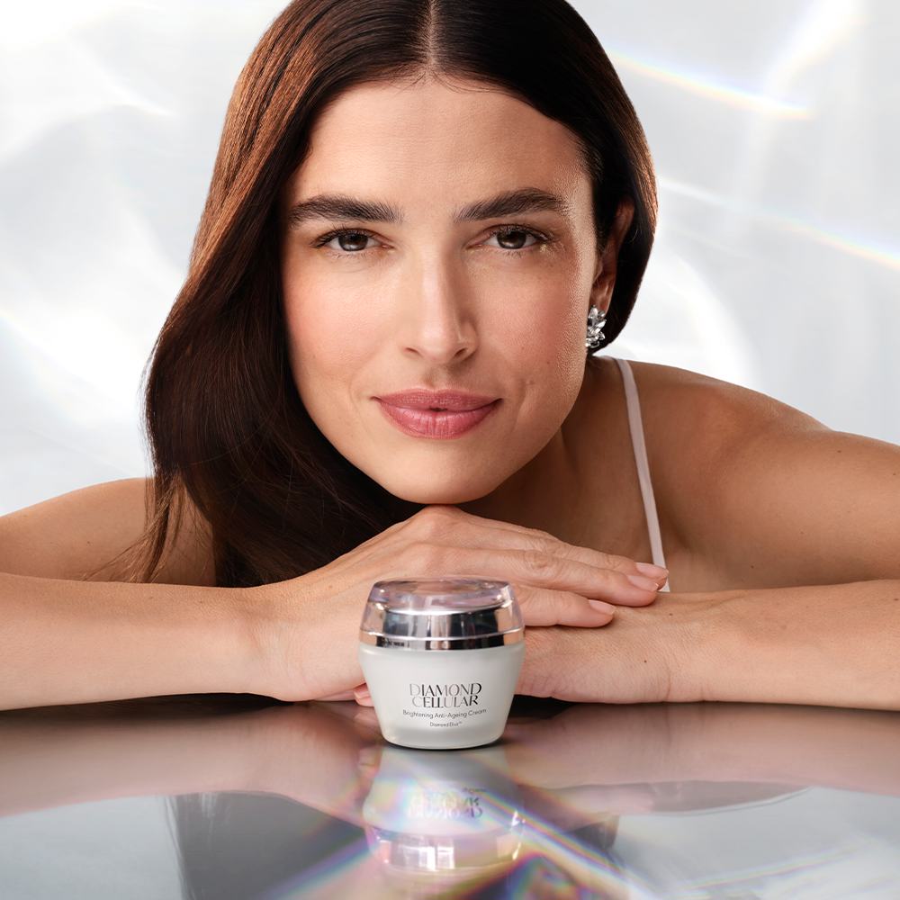 en kvinna som lutar sig mot ett bord med korsade armar