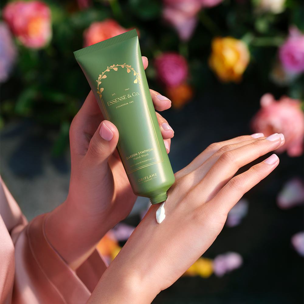 Una persona aplicándose crema en las manos.