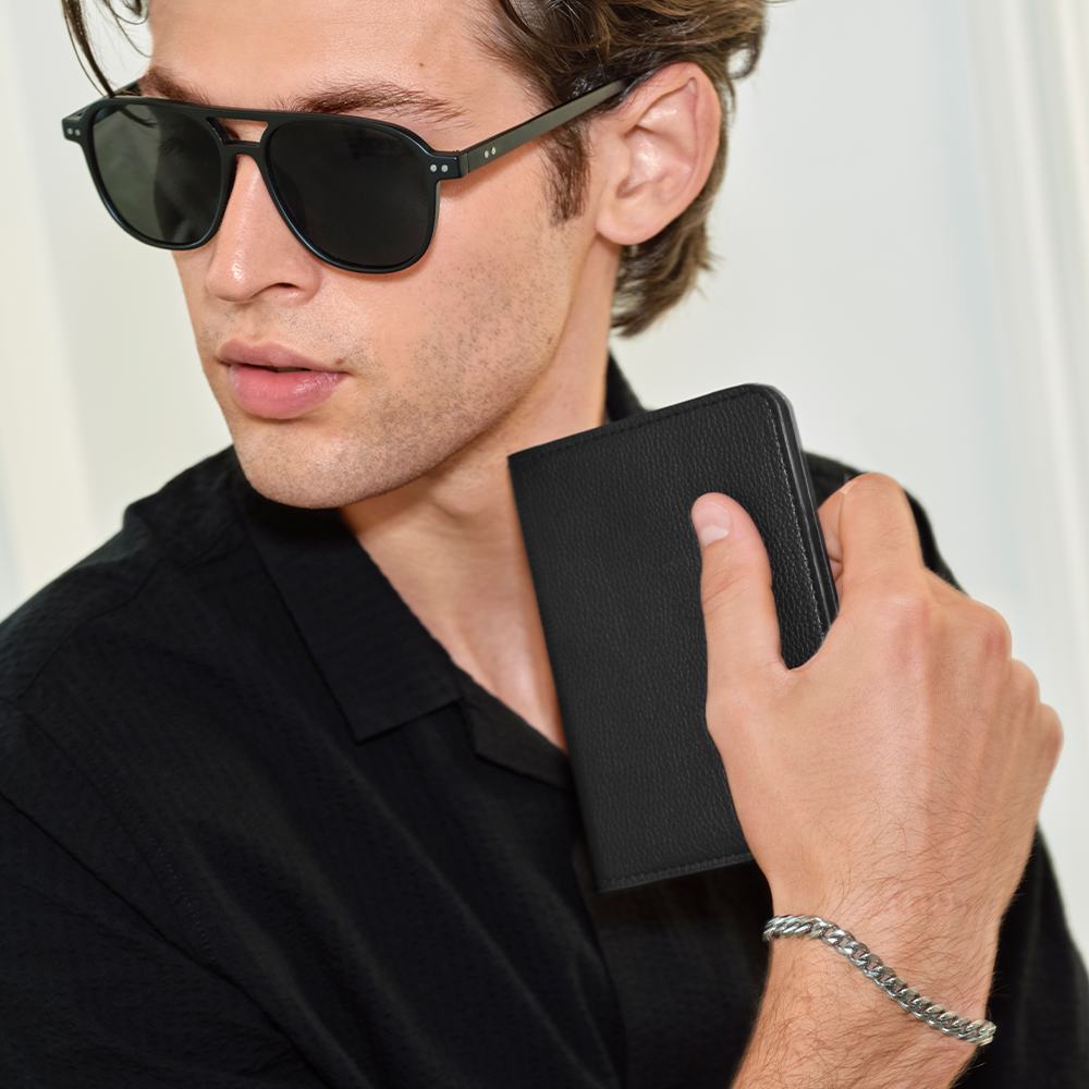 ένας άνδρας που φοράει γυαλιά ηλίου και κρατά ένα πορτοφόλι